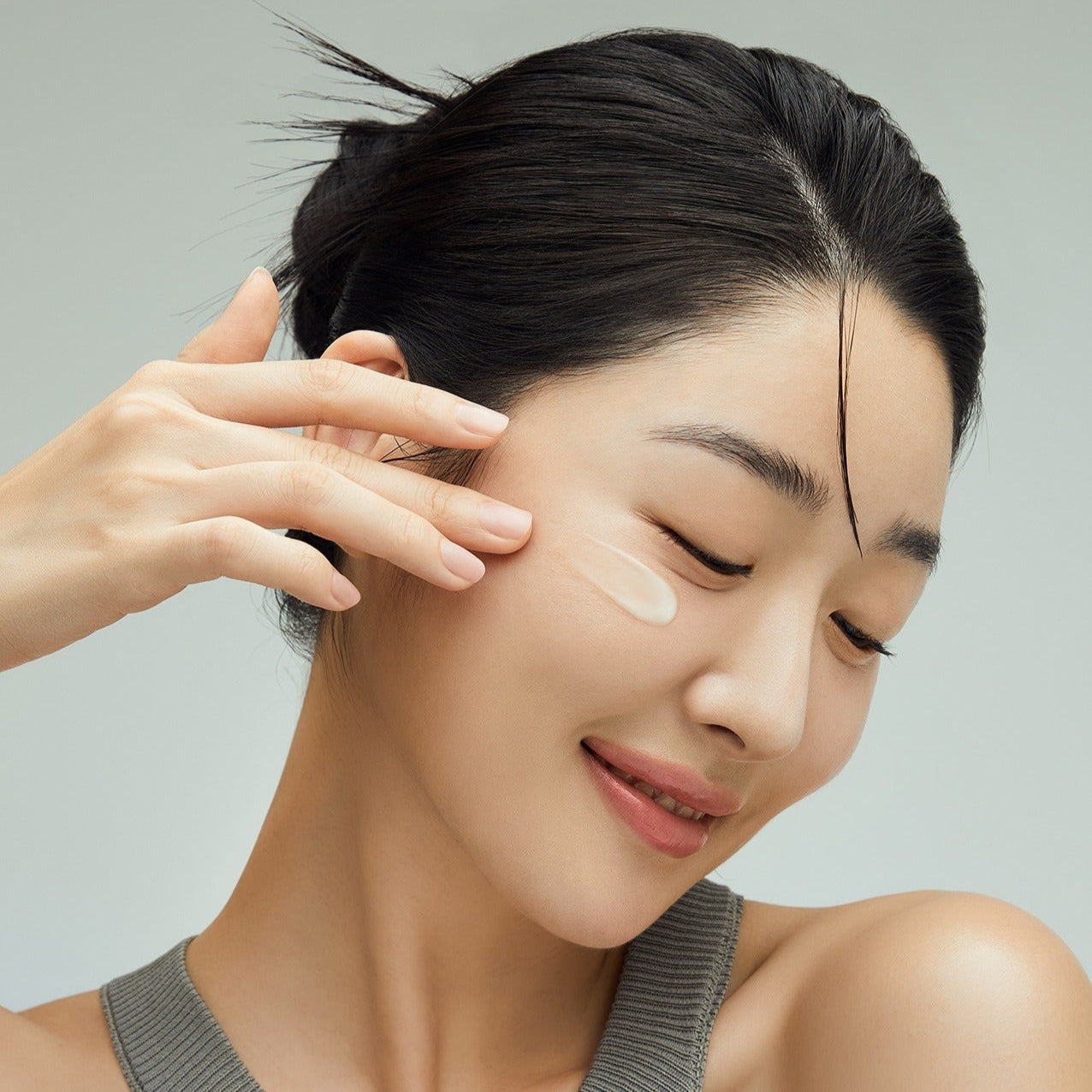 Woman applying FULLY Green Tomato Cream 90ml to face