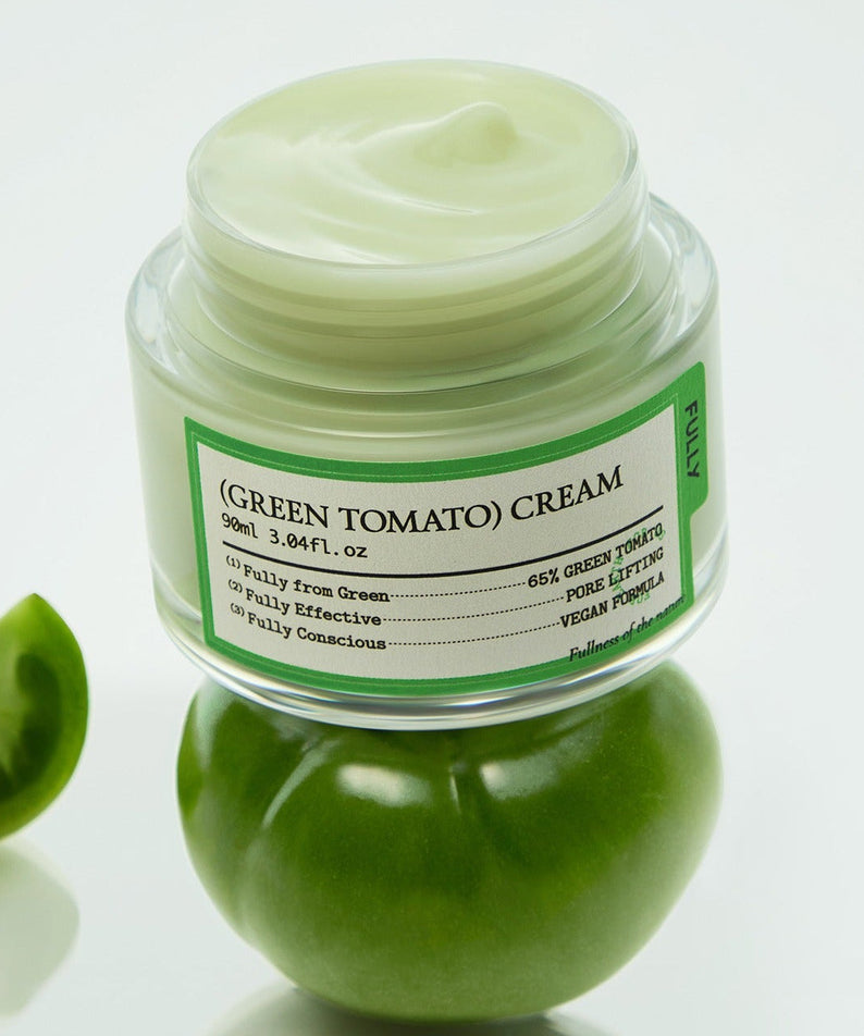 Image of FULLY Green Tomato Cream 90ml jar resting on fresh green tomato, highlighting eco-friendly skincare product.