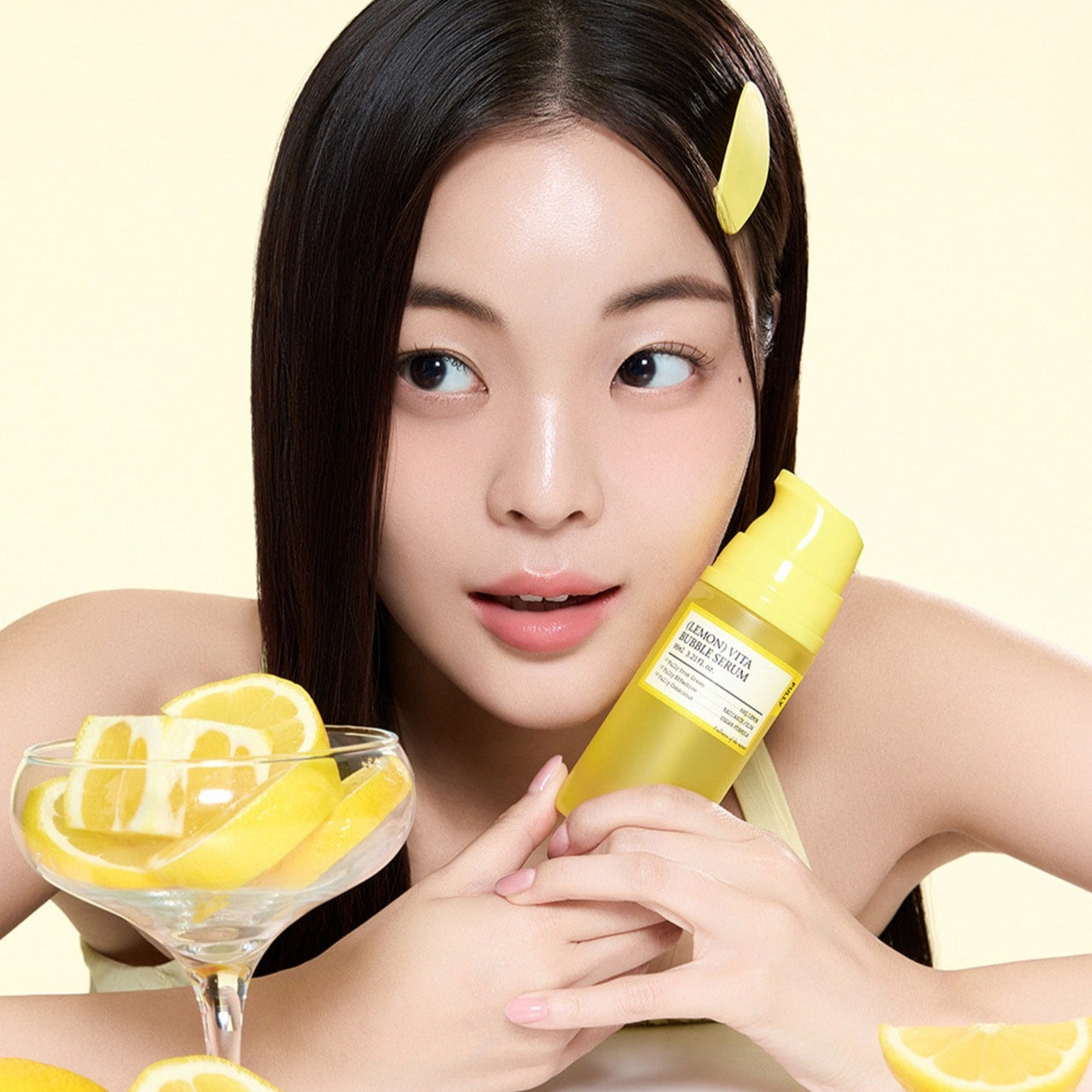 Woman holding FULLY Lemon Vita Bubble Serum 95ml beside sliced lemons, showcasing skincare benefits and packaging.