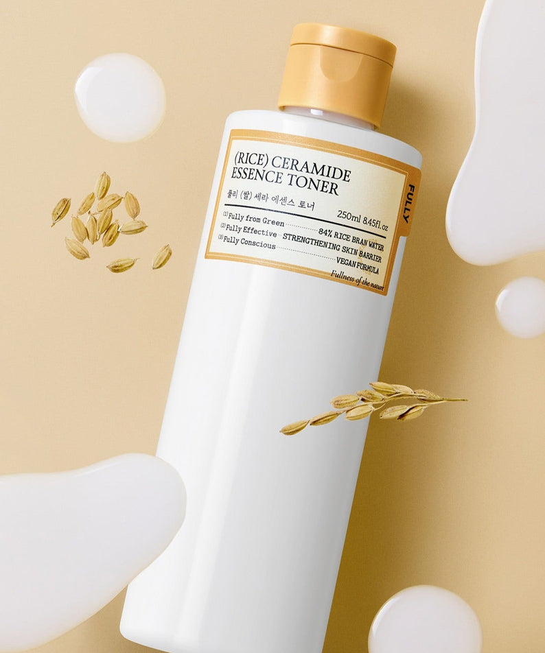 Bottle of FULLY Rice Serum Essence Toner 250ml with rice grains and liquid splashes on beige background