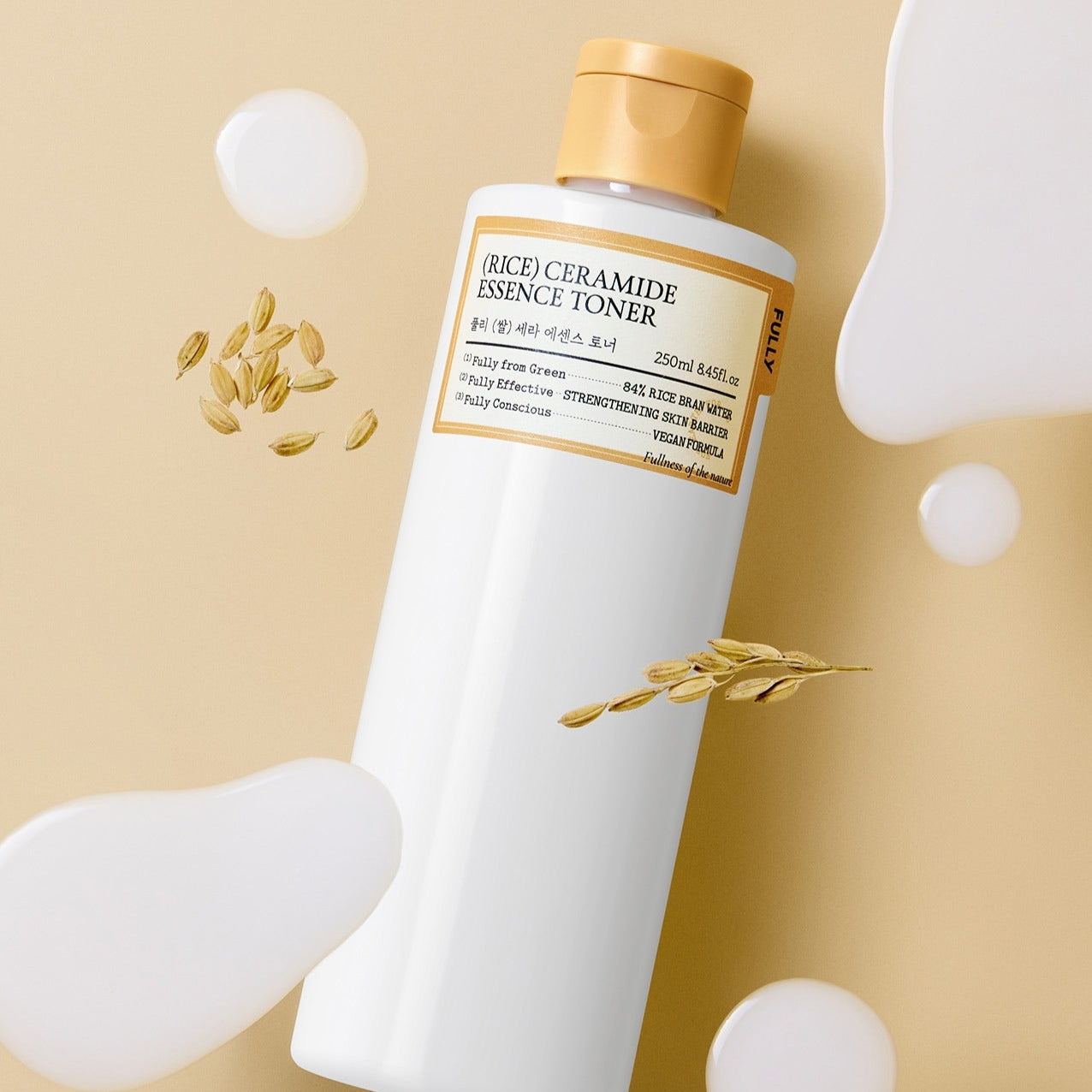 Bottle of FULLY Rice Serum Essence Toner 250ml with rice grains and liquid splashes on beige background