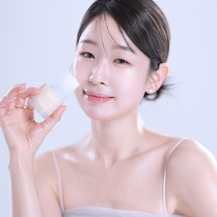Person holding a bottle of FWEE Foundation Glass, showcasing the product's design and appearance.