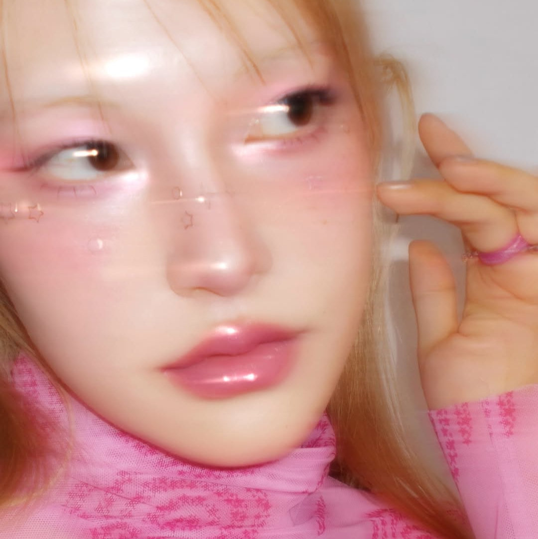 Close-up of a person wearing pink makeup, showcasing a glossy and ethereal look with FWEE Glitz Stone Highlighter.