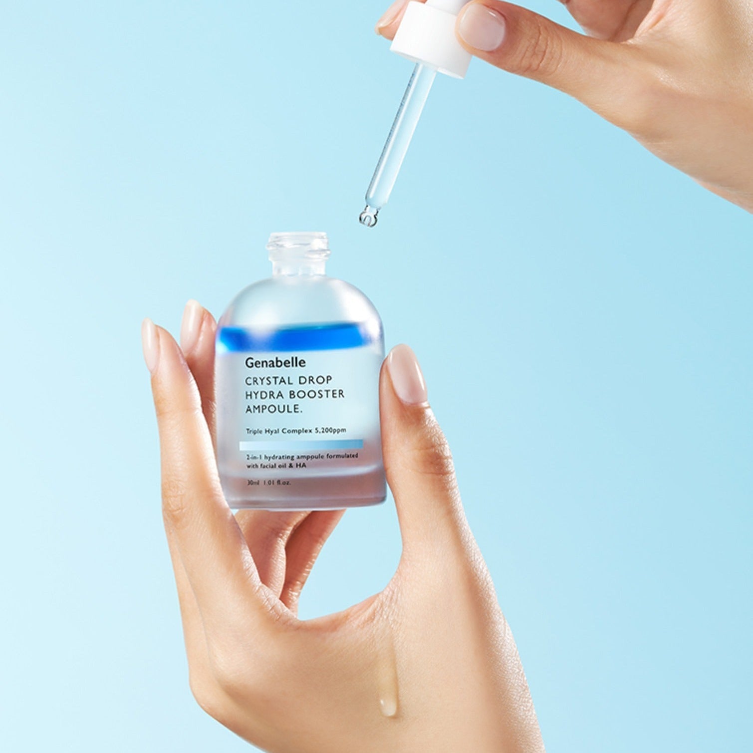 GENABELLE Crystal Drop Hydra Booster Ampoule 30ml held by hands with dropper against blue background