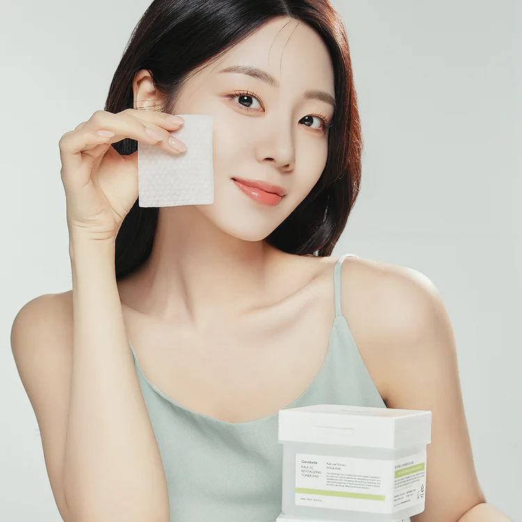 Woman using GENABELLE Kale 82 Revitalizing Toner Pad 60ea, holding a pad to her face with product packaging visible.