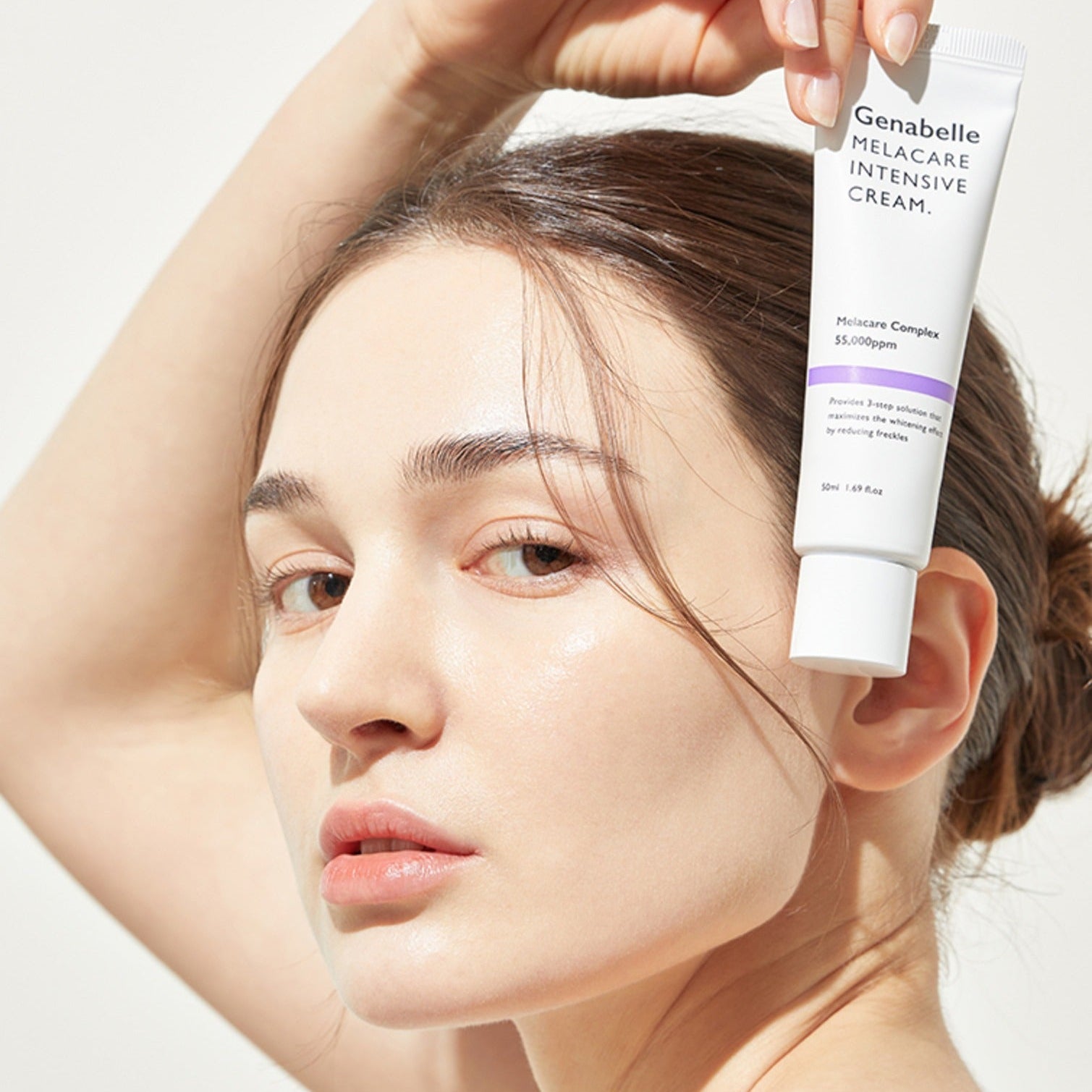 Woman holding GENABELLE Melacare Intensive Cream 50ml next to her face, showcasing product packaging and skincare benefits.