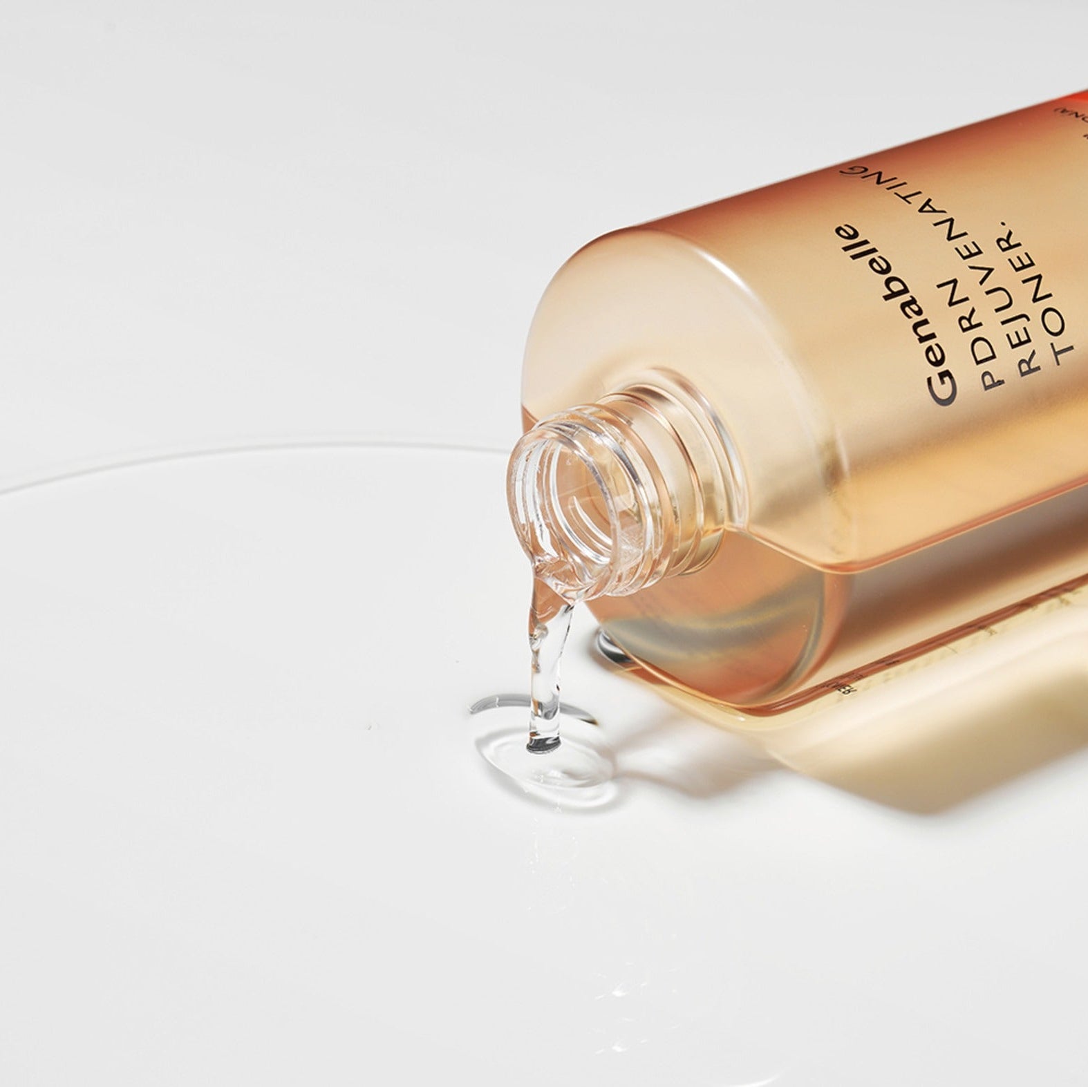 GENABELLE PDRN Rejuvenating Toner 300ml pouring on surface, depicting the product's lightweight texture and skin-refreshing formula.