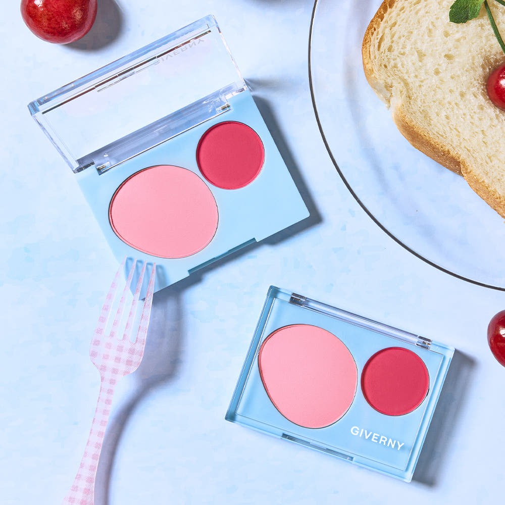 GIVERNY Fluffy Dual Blusher 7.4g, pink and red blush shades in a compact case beside a pink fork and bread slice.
