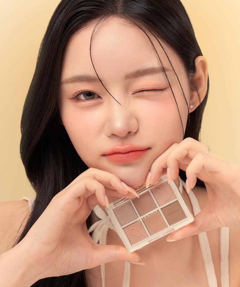 Woman holding GIVERNY Soft Eye Palette 6-Color 5g (3 Colors) near her face, displaying the eyeshadow shades.