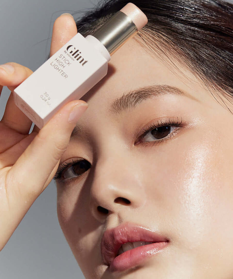 Model applying GLINT Stick Highlighter for a glowing look