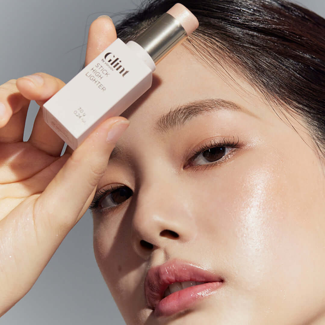 Model applying GLINT Stick Highlighter for a glowing look