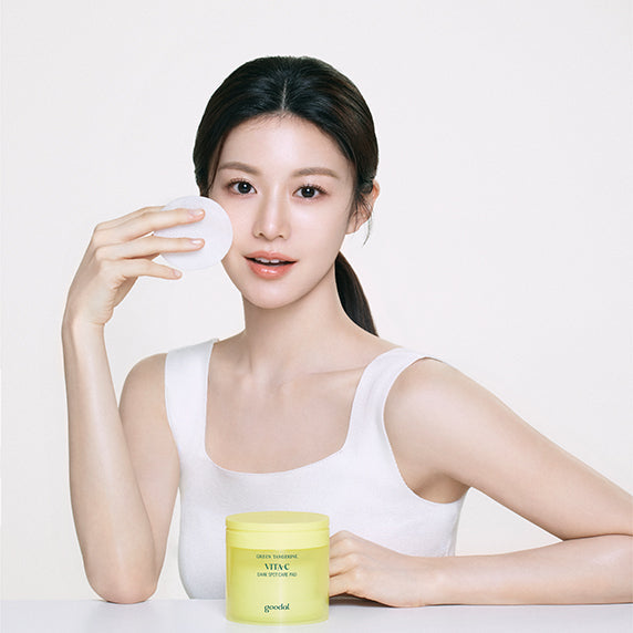 Model using GOODAL Green Tangerine Vita C Dark Spot Care Pad 160ml/70p for radiant skin; product promotes exfoliation and hydration.
