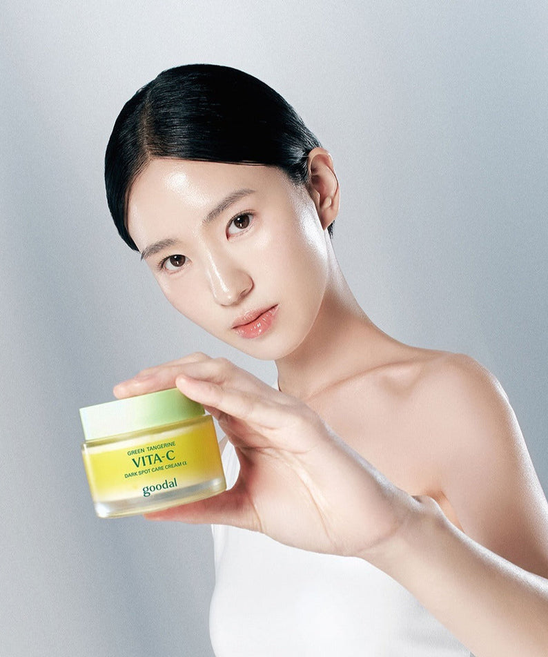 Woman holding GOODAL Green Tangerine Vita C Spot Care Cream Alpha 75ml jar in hand.