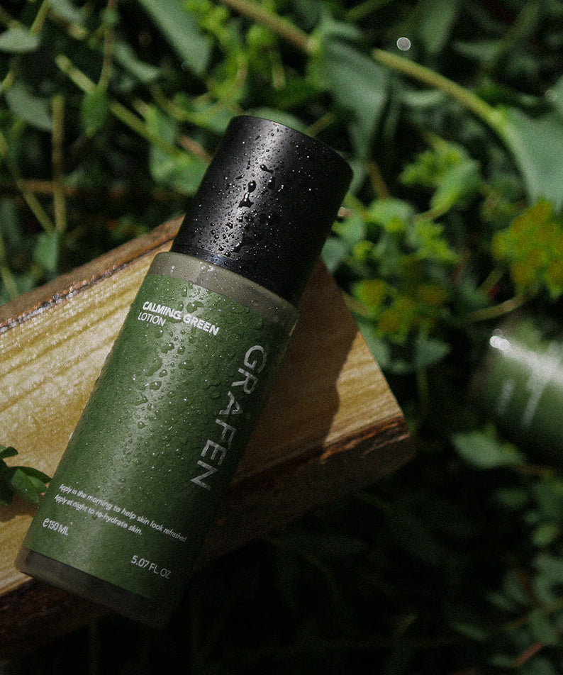GRAFEN Calming Green Lotion 150ml bottle on wooden plank with dewy leaves, Gentleman Korea men’s skincare product