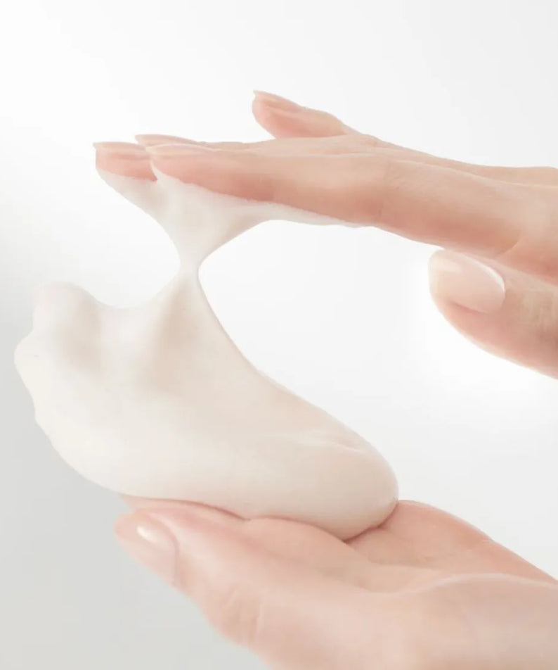 HANYUL Extreme Cream Cleansing Foam 200ml being applied with hands, showcasing its creamy texture.