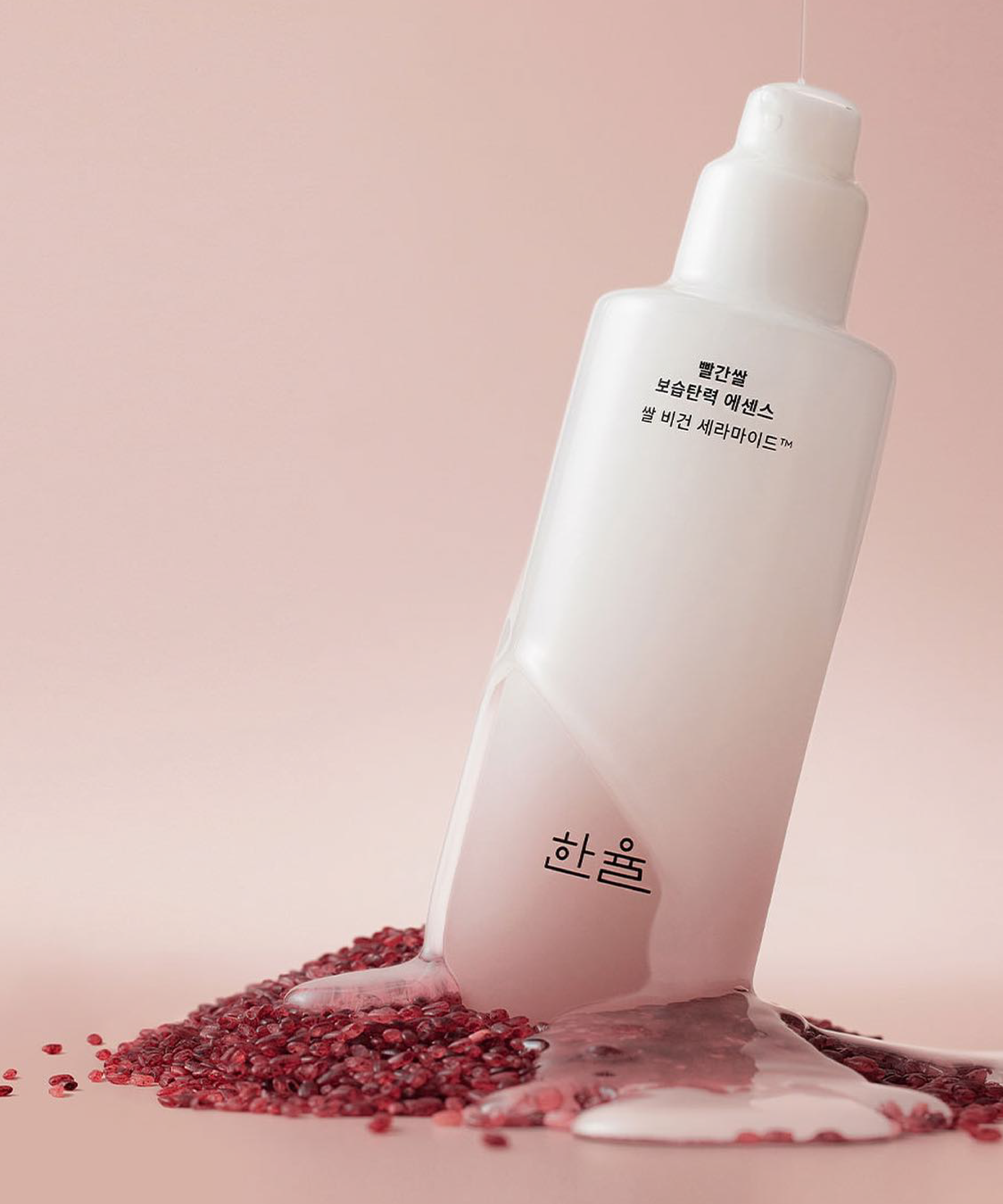 HANYUL Red Rice Moisturizing Elasticity Emulsion bottle on red rice background, showcasing product's hydrating properties.