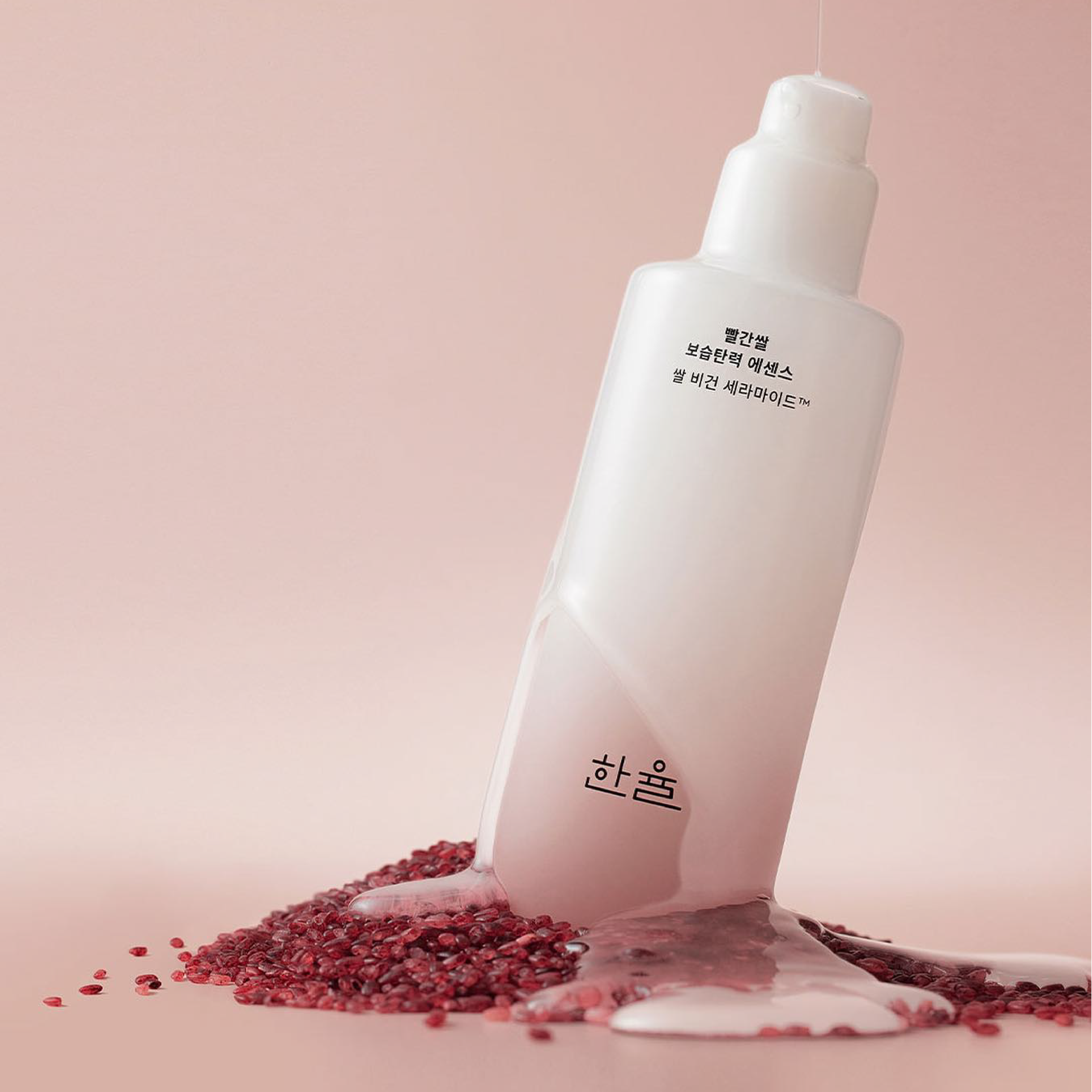 HANYUL Red Rice Moisturizing Elasticity Emulsion bottle on red rice background, showcasing product's hydrating properties.