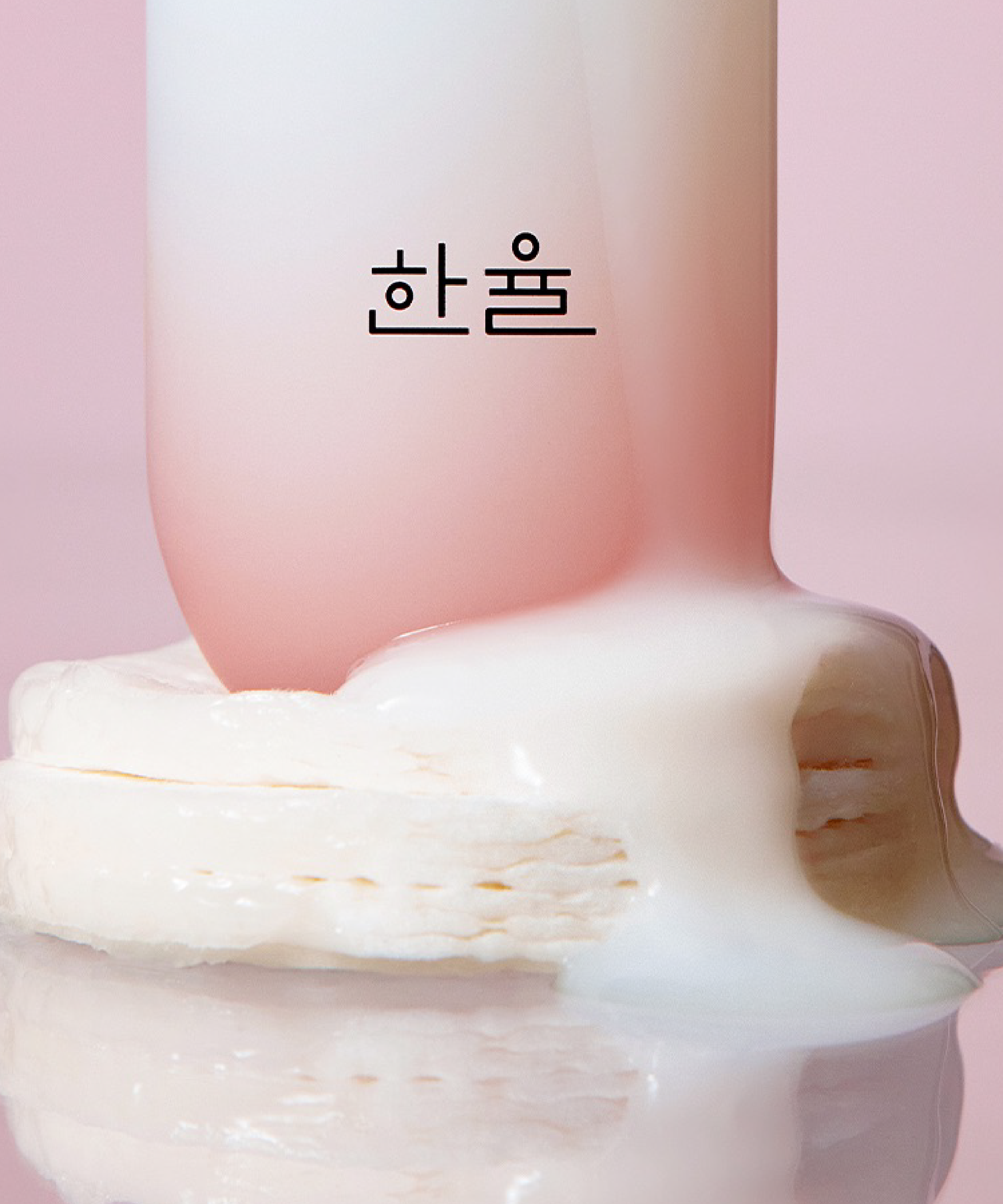 HANYUL Red Rice Moisturizing Elasticity Emulsion bottle with creamy texture on pink background