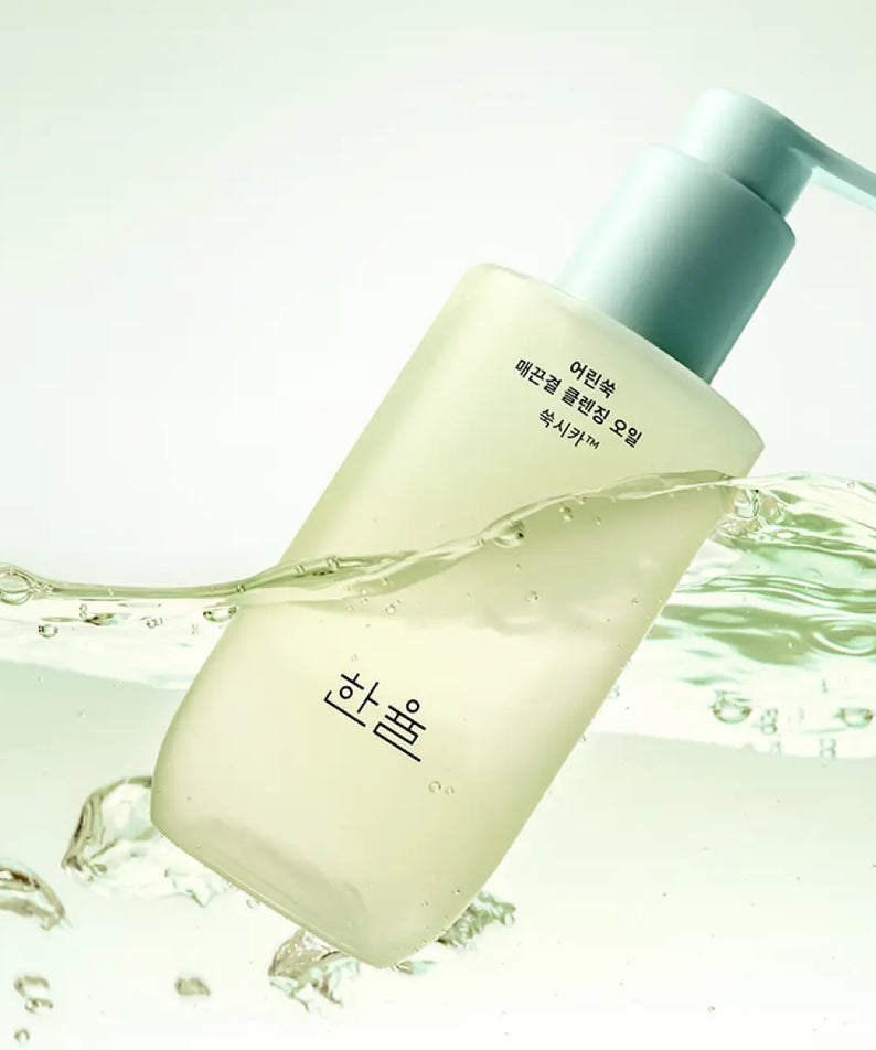 HANYUL Young Artemisia Smooth Cleansing Oil 200ml in a green bottle with a pump, surrounded by swirling oil and bubbles.