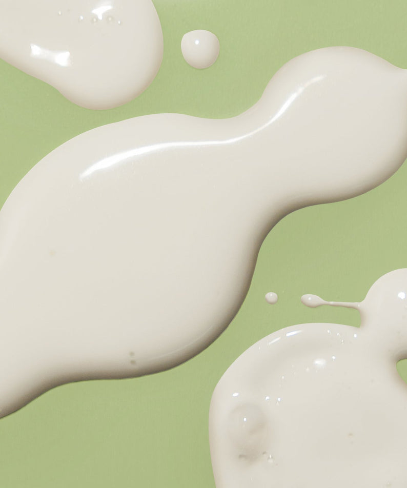 Texture of HARUHARU Black Bamboo Daily Smoothing Body Oil 200ml on a green background