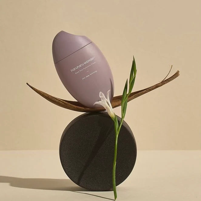 HARUHARU Black Rice 10 Hyaluronic Cream 50ml container displayed creatively with natural elements in a minimalistic setting
