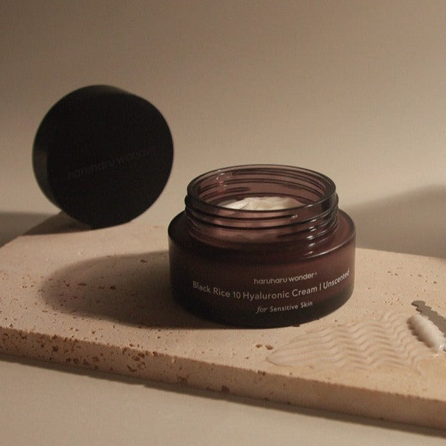 HARUHARU Black Rice 10 Hyaluronic Unscented Cream 50ml open jar on a marble surface for skincare.