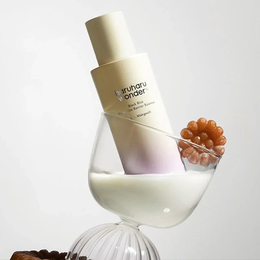 HARUHARU Black Rice Probiotics Barrier Essence 120ml bottle in a glass with white liquid and decorative element.