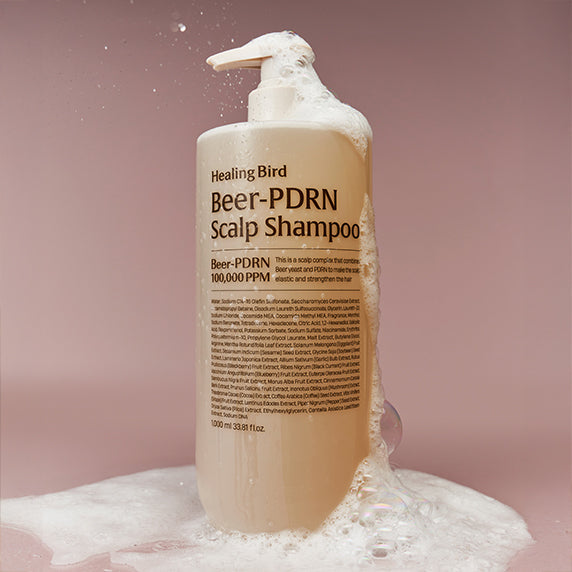 HEALING BIRD Beer PDRN Anti-Hair Loss Shampoo 1000ml bottle with foam on a pink background