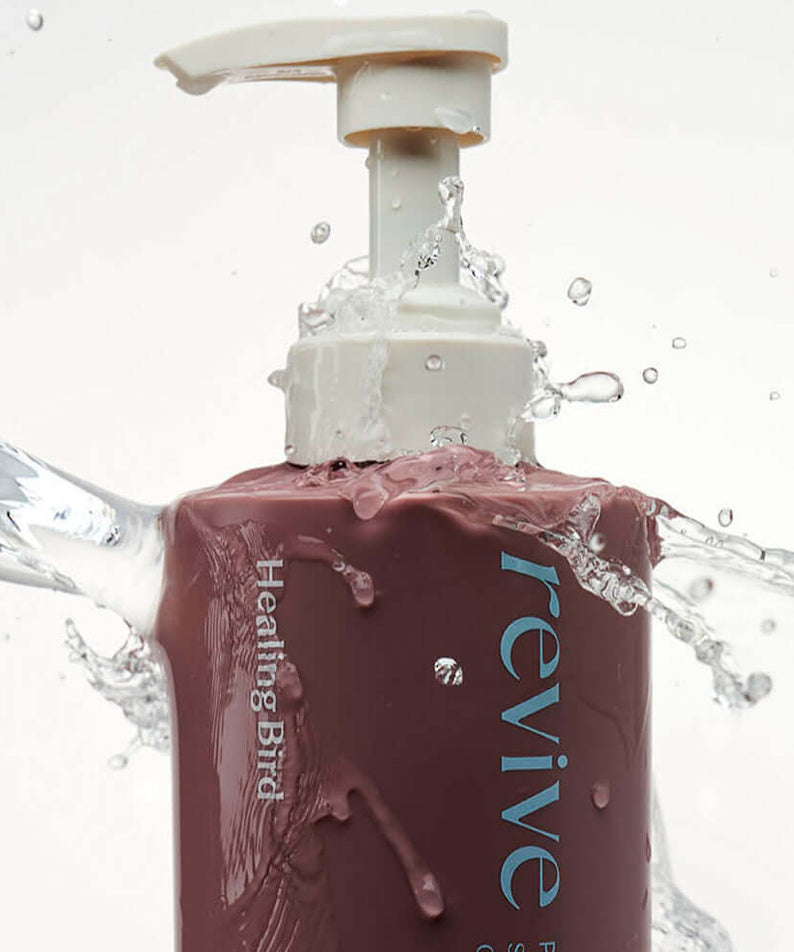 HEALING BIRD Revive Protein Shampoo 500ml bottle with water splash highlighting its hydrating properties