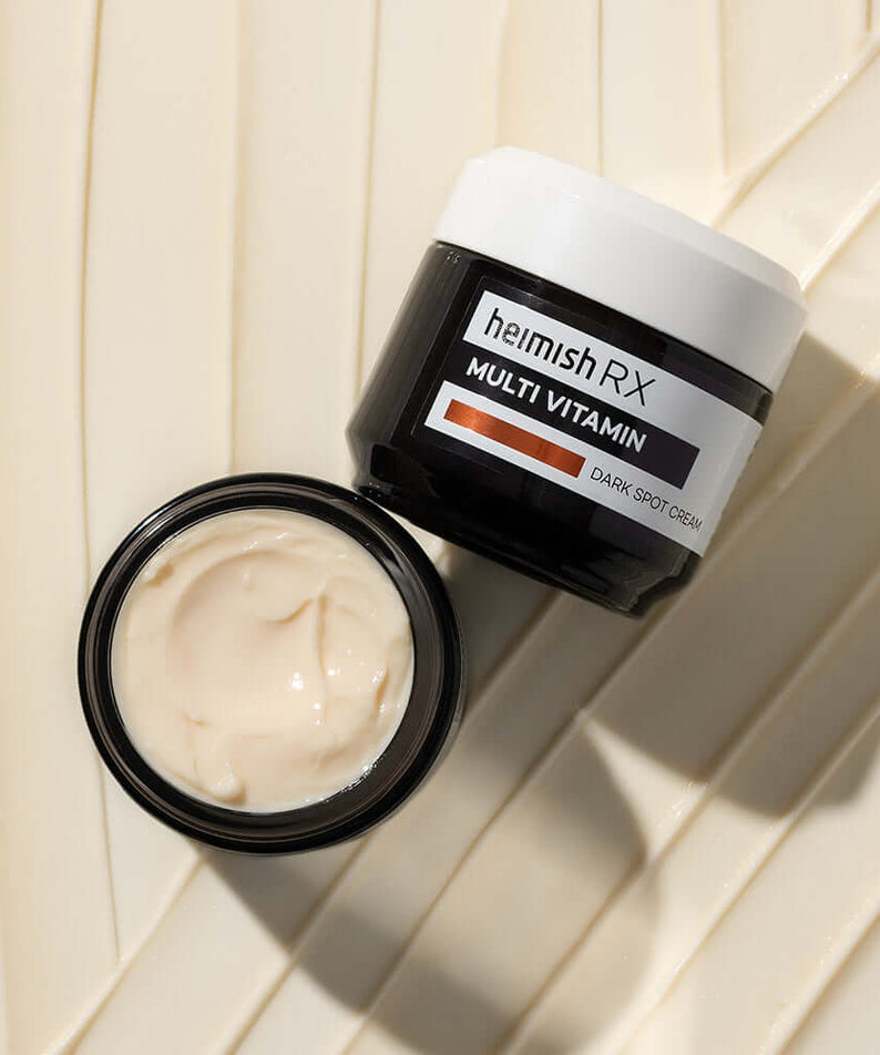 Open jar of HEIMISH RX Multi Vitamin Dark Spot Cream 50ml on a textured background.