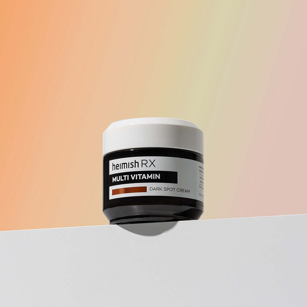 HEIMISH RX Multi Vitamin Dark Spot Cream 50ml jar on a gradient background