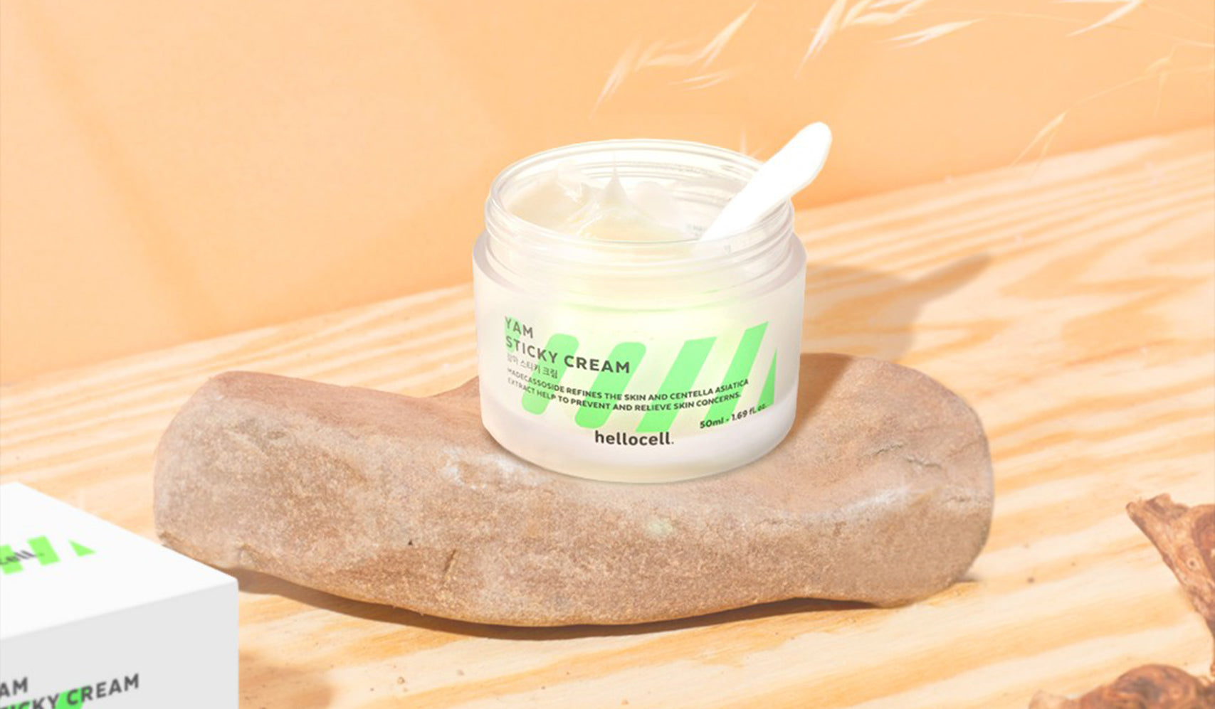 Heliocell Xiam sticky cream jar with a spoon on a natural stone surface, beige background.