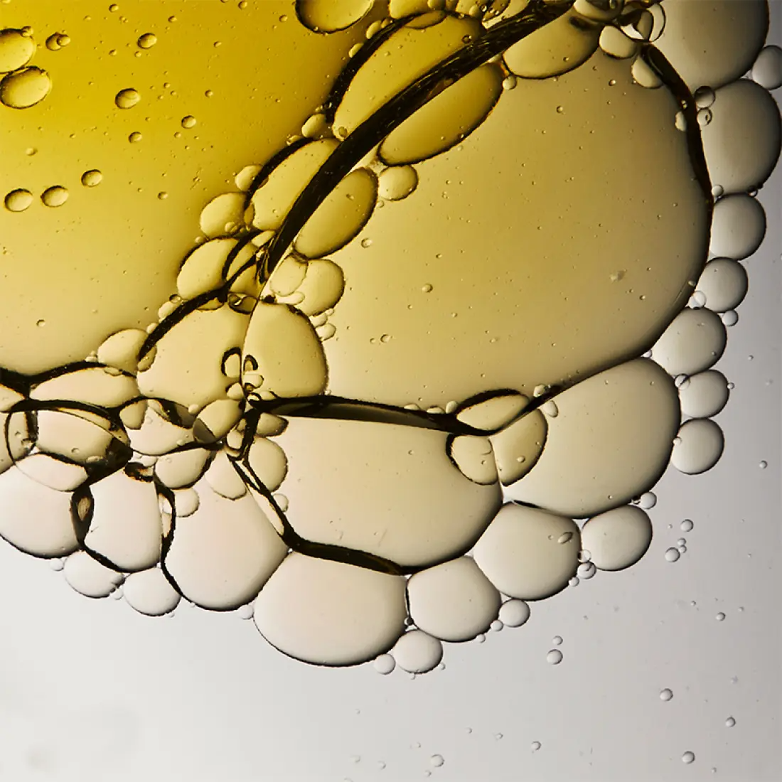 Close-up of oil droplets in water, resembling an abstract pattern, related to HERA Comfy Revitalizing Serum Mist 90ml ingredient texture.