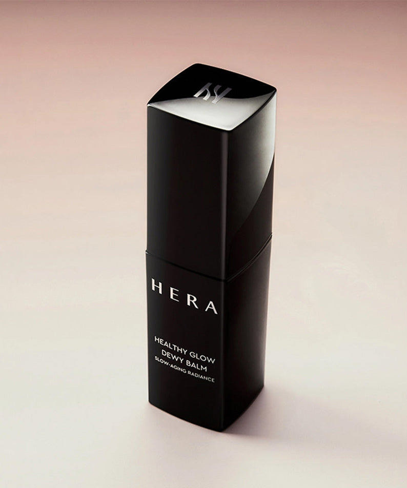 HERA Healthy Glow Dewy Balm 10g bottle showcasing product design against a soft background.