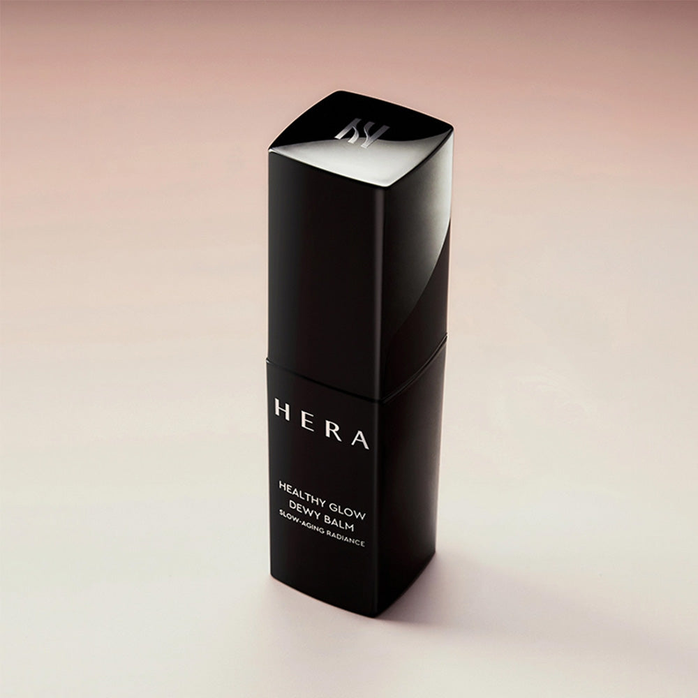 HERA Healthy Glow Dewy Balm 10g bottle showcasing product design against a soft background.