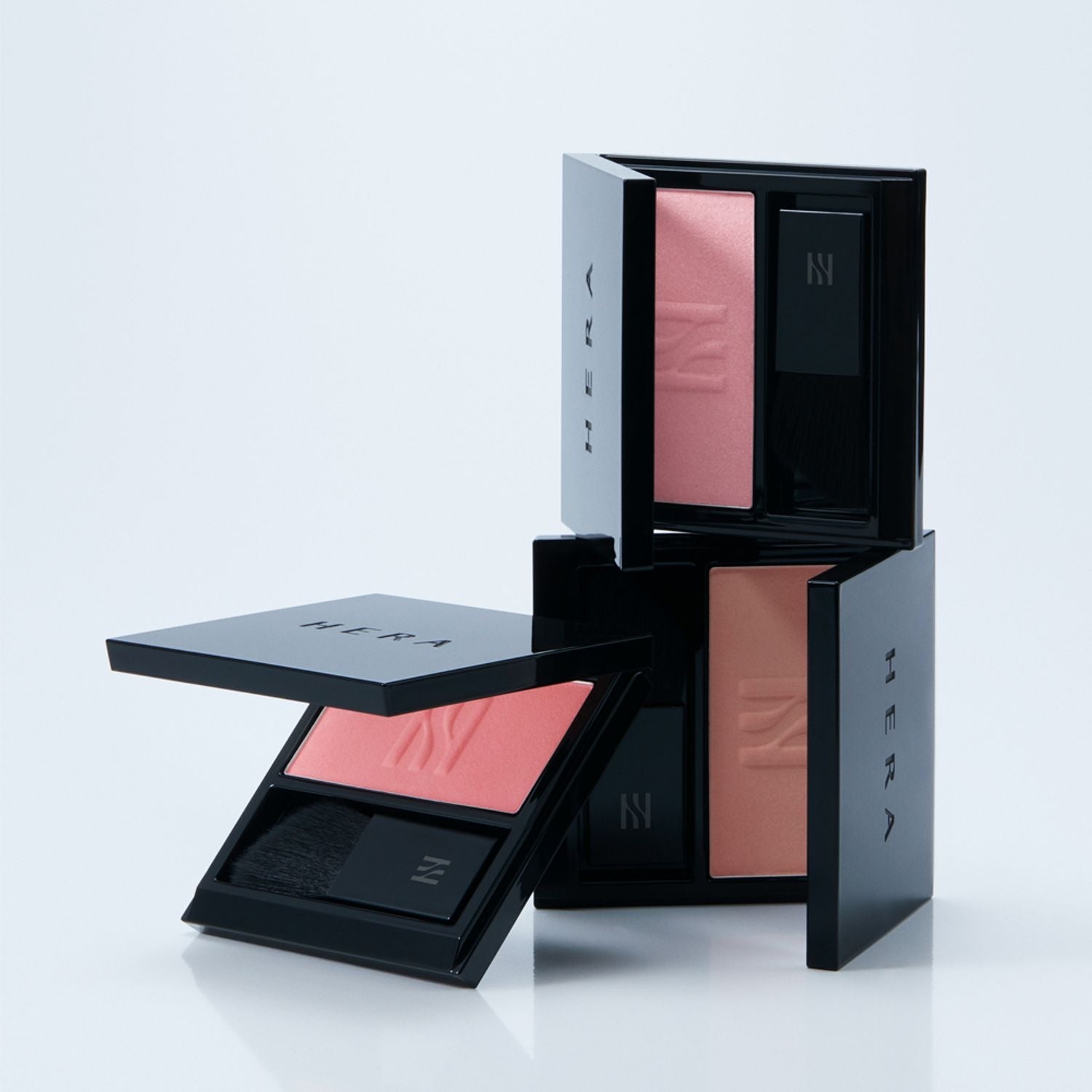 HERA Hera Blush 5.5g in black containers showcasing different shades of blush stacked creatively on a white background.