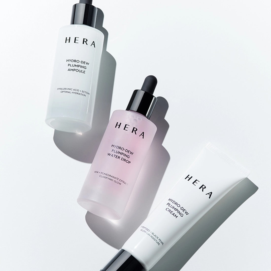 HERA Hydro-Dew Pluming Water Drop 50ml surrounded by skincare essentials in a bright setting.