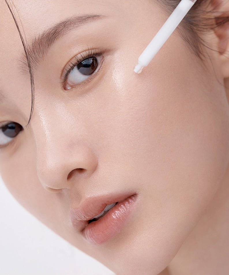 Woman applying HERA Hydro-Dew Plumping Ampoule 50ml for radiant skin