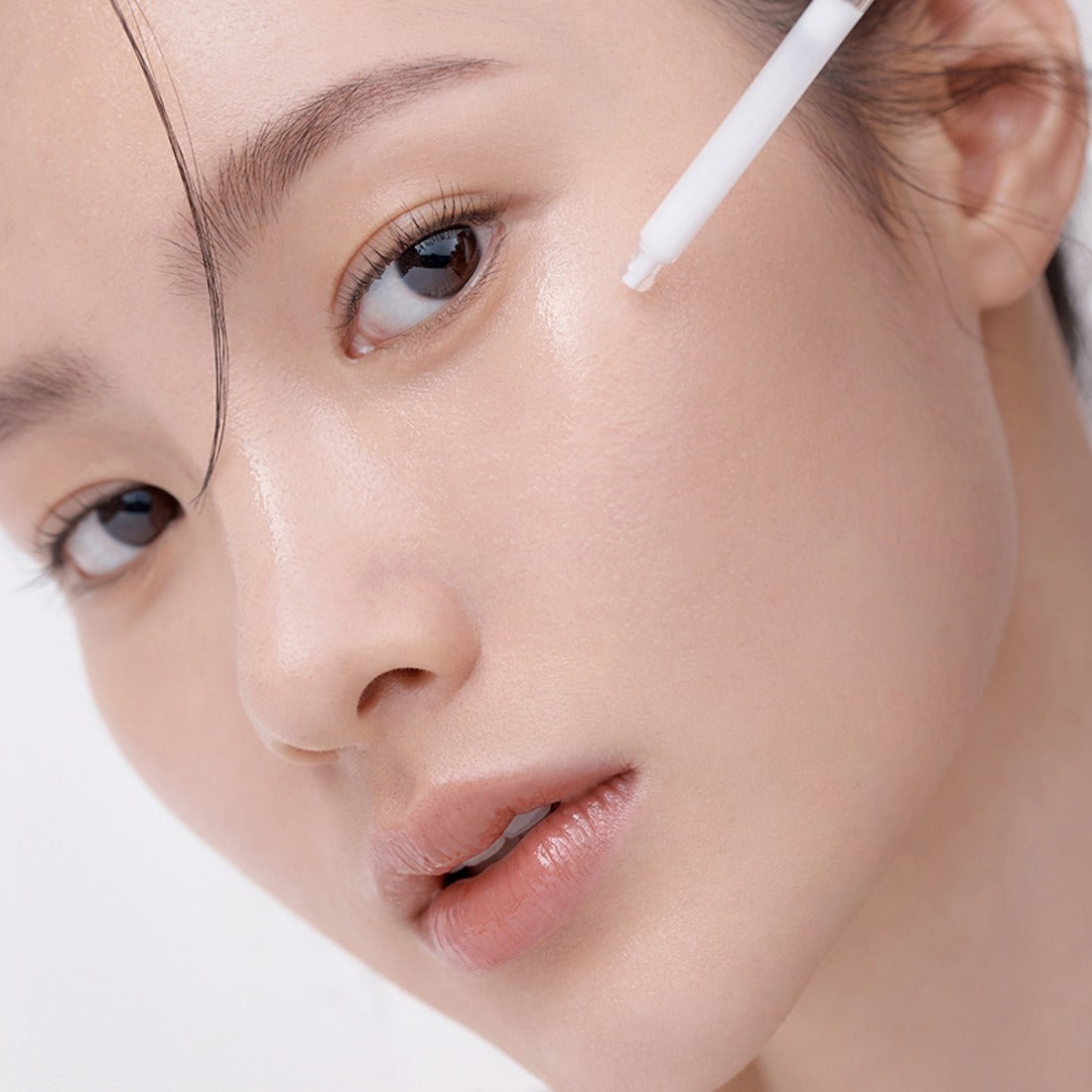 Woman applying HERA Hydro-Dew Plumping Ampoule 50ml for radiant skin