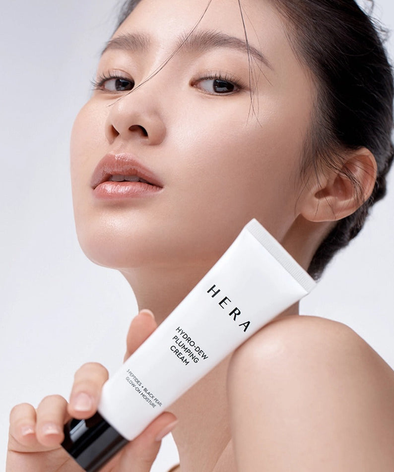 Woman holding HERA Hydro-Dew Plumping Cream 50ml with fresh, glowing skin