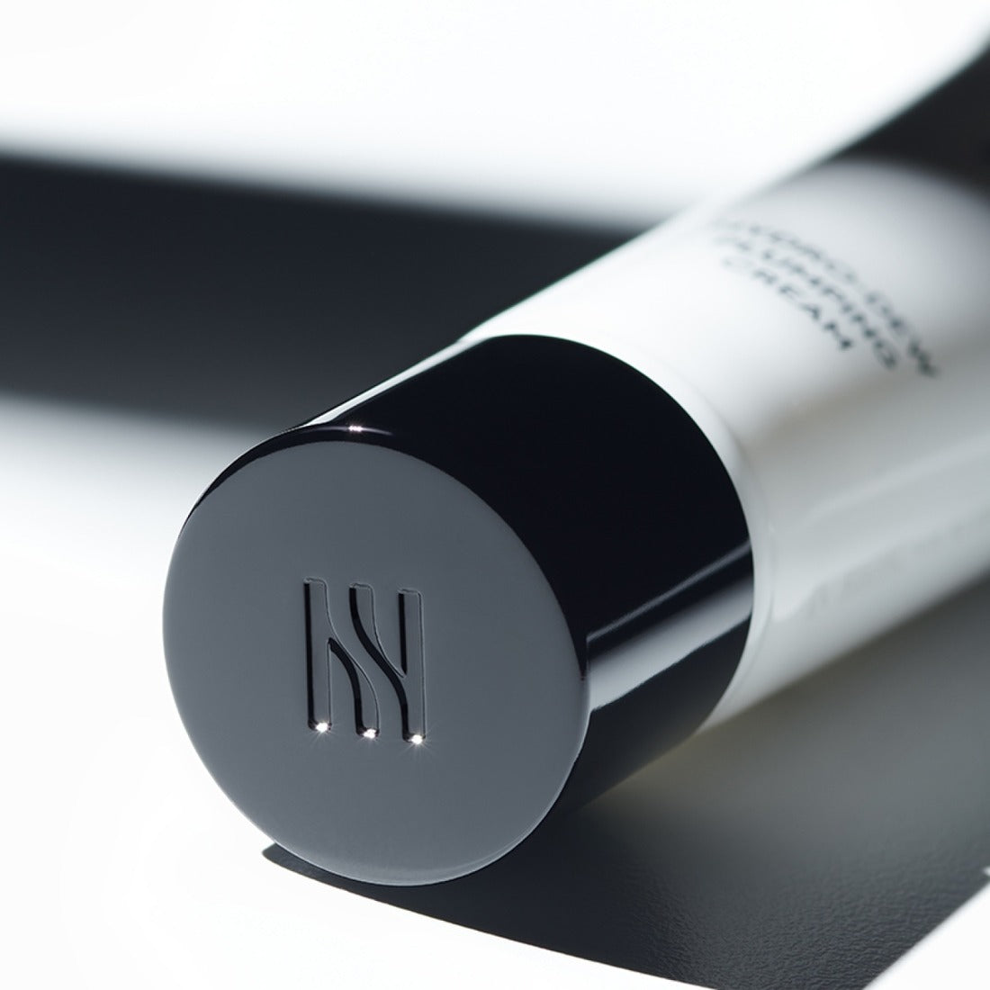 Close-up of HERA Hydro-Dew Plumping Cream 50ml cap on a white surface for skincare enthusiasts.