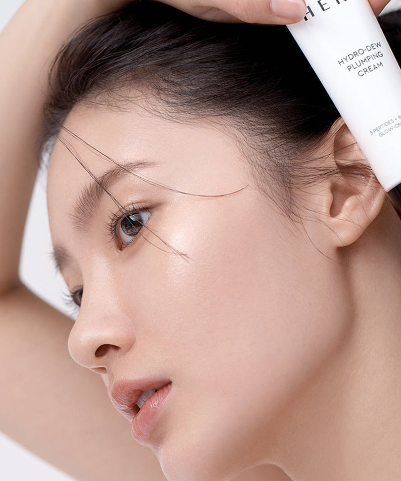 Woman applying HERA Hydro-Dew Plumping Cream 50ml for radiant skin