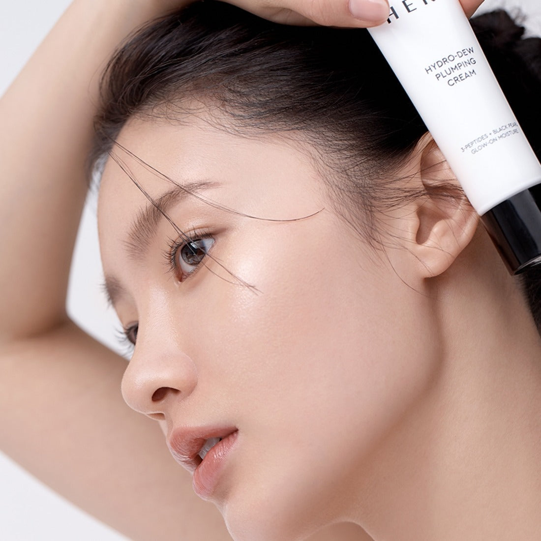 Woman applying HERA Hydro-Dew Plumping Cream 50ml for radiant skin