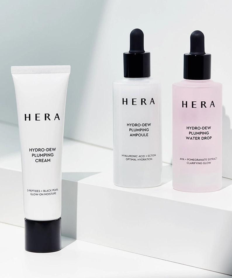 HERA Hydro-Dew Plumping Cream 50ml alongside ampoule and water drop bottles on display.