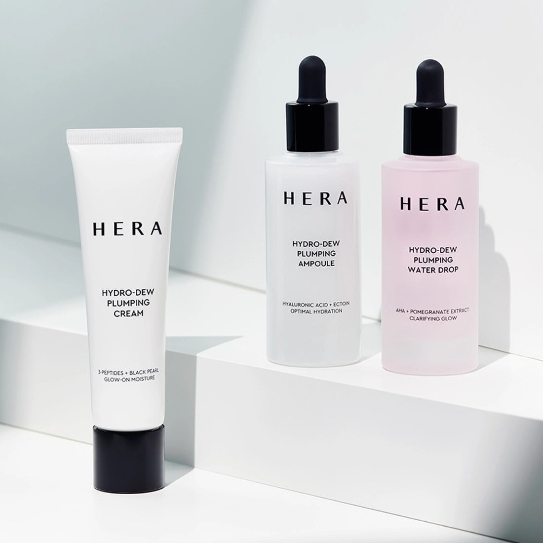 HERA Hydro-Dew Plumping Cream 50ml alongside ampoule and water drop bottles on display.