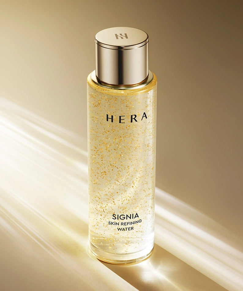 HERA Signa Skin refreshing Water 180ml bottle with golden highlights on a reflective surface.