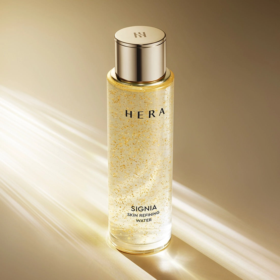 HERA Signa Skin refreshing Water 180ml bottle with golden highlights on a reflective surface.