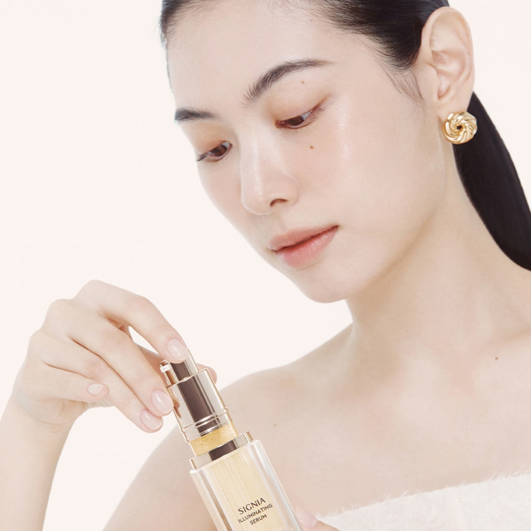 Person applying HERA Signia Illuminating Serum 30ml for radiant skin care
