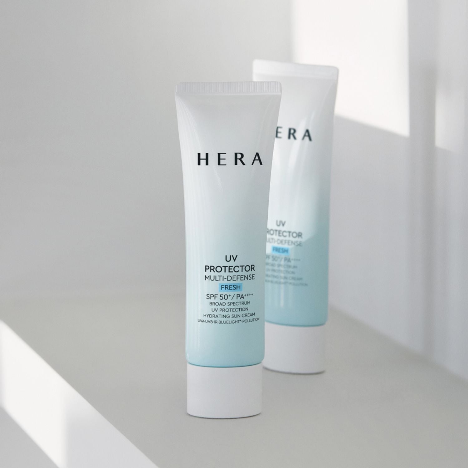 HERA UV Protector Multi-Defense Fresh SPF50+PA++++ 50ml on a white surface, offering superior sun protection and freshness.