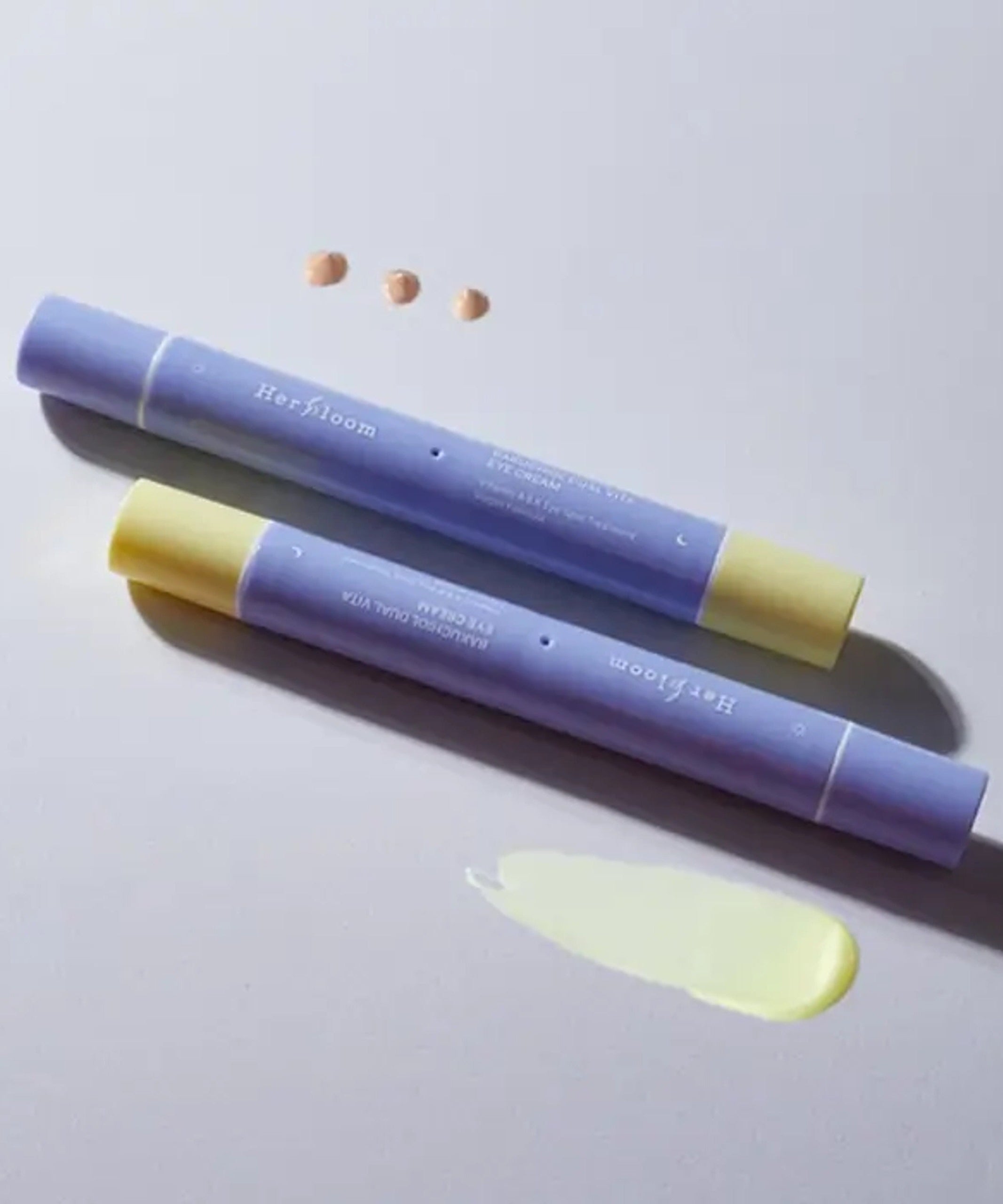 HERBLOOM Bakuchiol Dual Vita Eye Cream tubes with cream swatch on white background